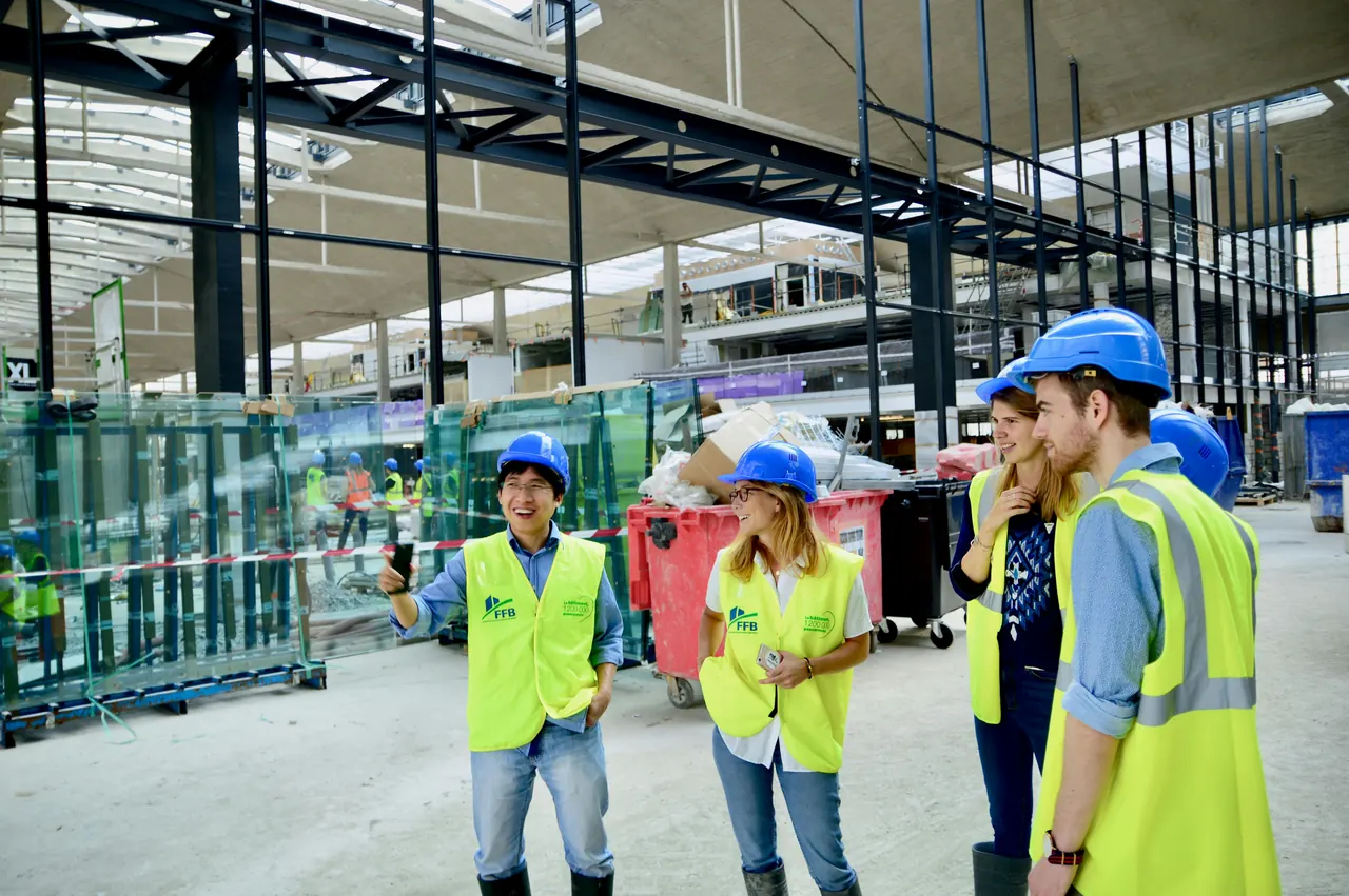 Construction workers gathered at a large building site