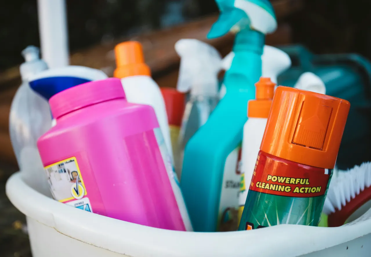 Cleaning products and brushes in a bucket